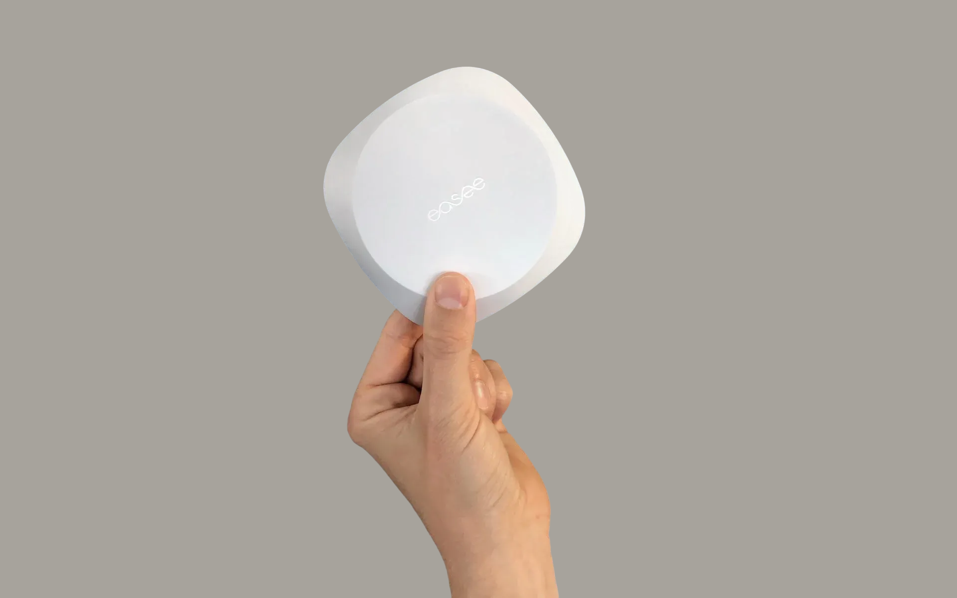 En hånd, der holder Easee Equalizer med to fingre