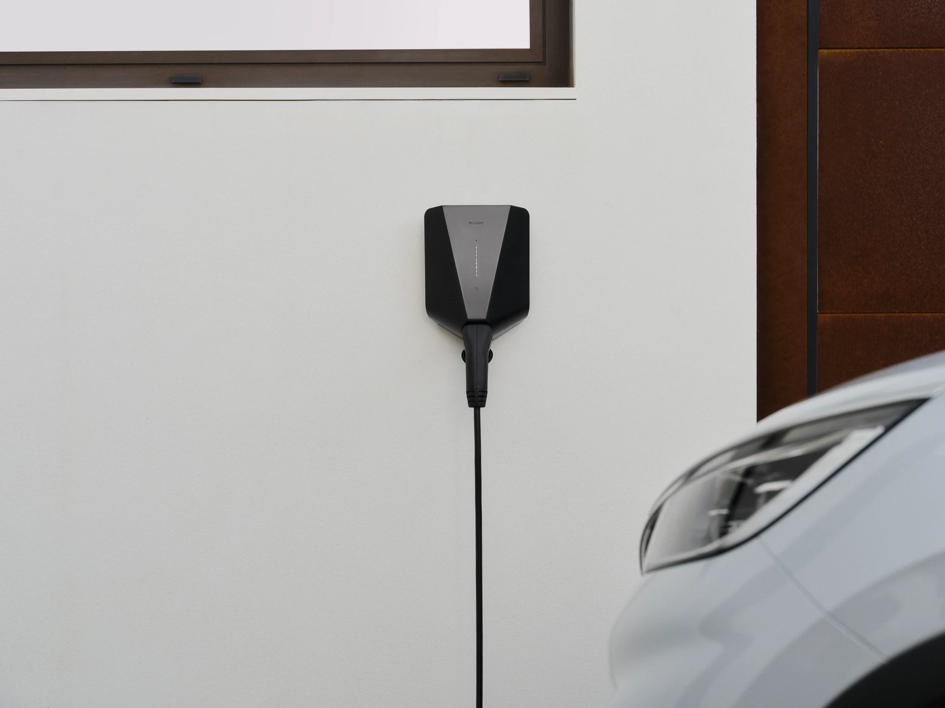 Easee-lader gemonteerd aan een muur die een elektrische auto oplaadt